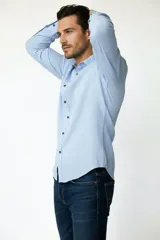 Camisa de viscosa color negro, de manga larga, con cuello camisero y cierre frontal de botones.