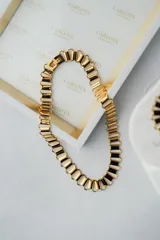 Gargantilla de eslabones rectangulares dorados y negros.