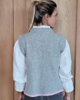 Chaleco tejido de punto con diseño abstracto en bloques de color marrón y turquesa, con cuello redondo y terminaciones acanaladas.