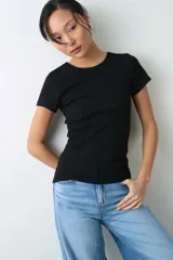 Remera negra de manga corta, confeccionada en tejido rib, con escote redondo y ajuste al cuerpo.