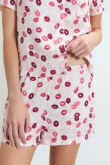 Pijama de dos piezas compuesto por una camisa de manga corta con botones frontales y un short, ambos con estampado de labios en tonos rosados y rojos.