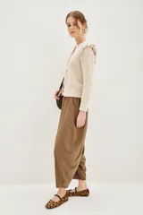 Pantalón tipo babucha de corte holgado y tiro alto, con cintura elástica y diseño de pierna amplia que se estrecha hacia los tobillos.