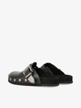 Zueco de cuero liso negro con plantilla anatómica forrada en gamuza, hebilla ajustable de estilo western en metal envejecido y tachas metálicas en el contorno.