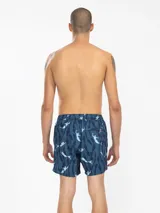 Short de baño azul con estampado de sirenas y algas en blanco.