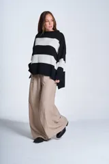 Sweater de punto con rayas horizontales anchas en blanco y negro. De corte amplio y relajado, brinda máxima comodidad sin perder el estilo. Su diseño atemporal lo convierte en una prenda versátil, ideal para combinar con jeans o pantalones para un look casual y abrigado en los días más frescos.