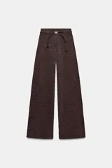 Pantalón de tiro alto con pierna recta y cintura elástica. Incluye un cinturón fino a contraste con detalle de pieza metálica central.