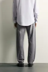 Jeans regular fit de mezclilla negra con efecto lavado, corte recto y tiro medio. Cuenta con diseño de cinco bolsillos y cierre frontal con cremallera y botón.