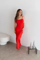 Vestido largo rojo vibrante, de corte liso y ajustado al cuerpo, con tirantes finos y escote recto.