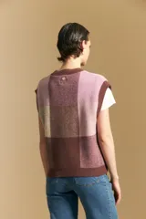 Chaleco tejido de punto con diseño de bloques a cuadros en tonos rosados, marrones y beige. Presenta cuello redondo y terminaciones acanaladas en cuello y sisas.