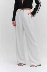 Pantalón de corte recto y tiro medio color blanco, confeccionado en crepé. Cuenta con trabillas en la cintura y cierre frontal adornado con dos botones joya.