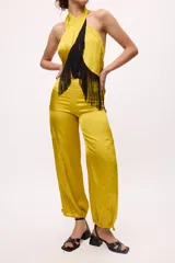Pantalón ancho de seda color amarillo, estilo parachute o globo, con talle alto y cordones ajustables en los tobillos.