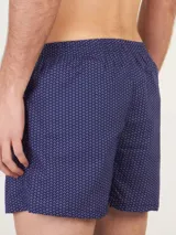 Bóxer de algodón blanco con estampado de flores pequeñas color celeste, con cintura elástica y logo de la marca en el centro.