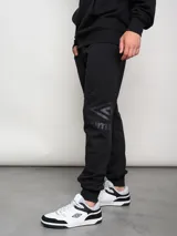 Pantalón de jogging azul marino de felpa con puños elásticos y logo de la marca estampado en la pierna izquierda.