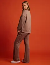 Buzo blanco de tejido elastizado, con pespunte central en la parte delantera y tajos laterales.