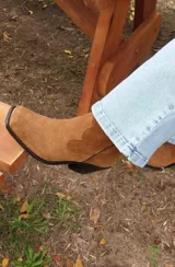 Bota texana de cuero color beige con detalles de costuras y cierre lateral.