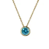 Collar de cadena fina con dije de punto de luz circular que contiene una circonita verde engastada en acero quirúrgico con baño de oro.