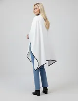 Ruana negra de tejido suave, con cierre frontal de botones metálicos y ribetes de cuero sintético en los bordes.