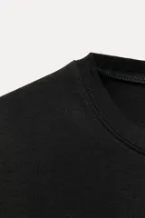 Camiseta de algodón color negro, con cuello redondo, manga corta y corte regular fit.