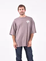 Remera oversize color rosa viejo de manga corta con pequeño estampado blanco en el pecho.