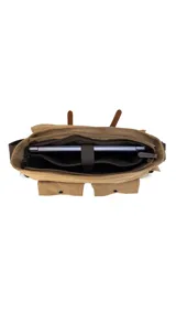 Morral de tela canvas color gris con detalles en cuero marrón, con tapa y doble bolsillo frontal, trasero y laterales. Interior espacioso con compartimento para notebook de 15". Correa de galón regulable para mayor comodidad.