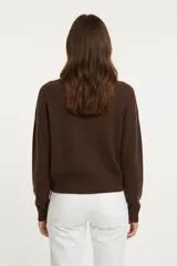 Sweater de tejido liso, color marrón oscuro, con cuello redondo a la base y calce holgado.