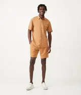 Camisa de hombre de manga corta color marrón, confeccionada en lino y algodón. Presenta cuello clásico, botonadura frontal, bolsillo en el pecho y mangas con botón para enrollar.