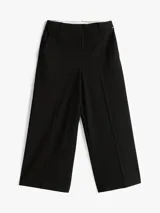 Pantalón negro de corte amplio, tobillero y talle bajo. Confeccionado en tejido antiarrugas de mezcla de viscosa elástica. Presenta cierre de cremallera con enganche oculto, raya marcada en la parte delantera y trasera, y dos bolsillos traseros de ojal.