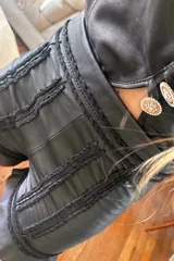 Short negro de cuero ovino con bordados y volados en el ruedo.