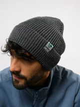 Gorro tipo beanie de punto acanalado en color negro, con vuelta y etiqueta de la marca Umbro cosida en el lateral.
