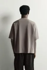 Camiseta de corte relajado confeccionada en algodón con elasticidad, con cuello redondo y diseño de manga larga con efecto doble. Presenta un acabado con efecto lavado.