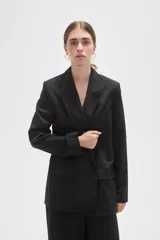 Blazer de corte holgado con diseño de rayas verticales, cuello solapa y cierre frontal con un botón. Cuenta con bolsillos laterales con solapa.