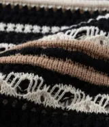 Blusa de punto ligero con cuello redondo, mangas cortas y rayas horizontales en tonos negro, beige y blanco.