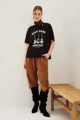 Remera de algodón color negro, con cuello redondo y mangas cortas. Presenta un estampado frontal con tres guitarras y la inscripción 'Rock Hard Forever' en color crema.