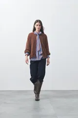 Cardigan de textura suave y efecto fluffy, color beige, con cuello redondo, cierre frontal con botones y puños acanalados.