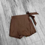 Short pollera color chocolate con detalle de lazo en la cintura.