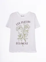 Remera blanca de manga corta y cuello redondo, con estampado floral en tono verde y texto "Les Fleurs Éclosent" en marrón.