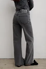 Pantalón de jean negro de corte recto y tiro medio, con cierre frontal de botón y cremallera, y bolsillos laterales y traseros.