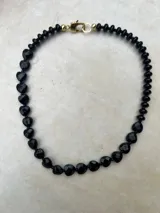 Collar de piedras naturales de ágata talladas en forma de corazón, con tonos verdes y violáceos, unidos por una fina cadena metálica.