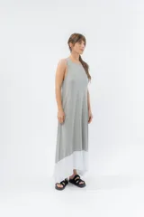 Vestido largo negro con base blanca, de corte suelto y sin mangas.