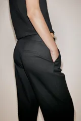 Pantalón de tiro medio con pernera recta, bolsillos delanteros y falsos bolsillos de vivo en la parte posterior. Cuenta con cierre frontal de cremallera, botón interior y gancho.