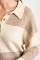 Sweater de punto con cuello polo y cierre frontal de tres botones. Presenta un diseño de corte oversize, mangas largas y textura acanalada.