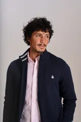 Cardigan de punto color azul marino, con cuello alto, cierre frontal completo y puños acanalados. Presenta el logo de la marca bordado en el pecho.
