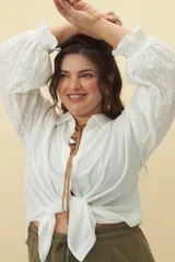 Camisa blanca de mangas largas con detalles bordados y cuello clásico.