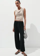 Pantalón negro de diseño balloon con tiro medio, cintura elástica y bajo con goma ajustable.