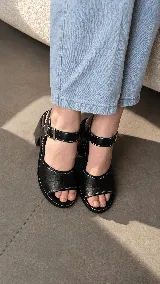 Sandalias de cuero combinadas en azul y negro, con diseño de textura croco en la capellada, costuras en contraste y taco ancho de madera. Poseen tira al tobillo con hebilla metálica regulable.