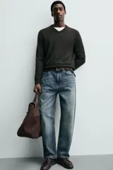 Jersey de punto de corte regular fit, confeccionado en hilatura de lana. Presenta cuello en pico, manga larga y acabados en rib.