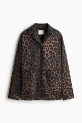 Campera de sarga de algodón con estampado animal print, cuello abierto, cierre frontal con botones y bolsillos delanteros de parche con solapa. Presenta hombros levemente caídos y puños abotonados.
