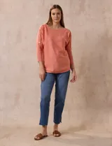 Buzo tejido color salmón de hilado fino, marca Cable & Gauge. Escote redondo con calados. Manga ¾, modelo dolman con aplique de botones dorados.