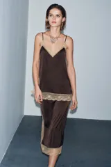 Top de tejido satinado color marrón oscuro, con escote recto y tirantes finos ajustables. Presenta aplicación de encaje color beige a contraste en el escote y el bajo.