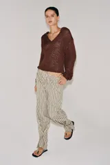 Pantalón de tiro medio con diseño de rayas verticales, confeccionado en mezcla de viscosa. Presenta cintura elástica ajustable con cordones, bolsillos laterales ocultos y pierna recta con bajo ajustable mediante botón.